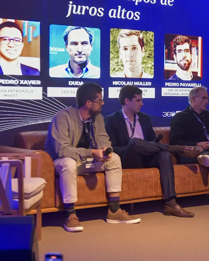 Mesa de debate no palco da 1ª edição, com quatro convidados sentados em poltronas