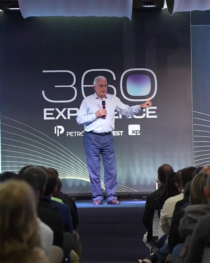 Palestrante no palco da 1ª edição, diante do painel do 360 Experience