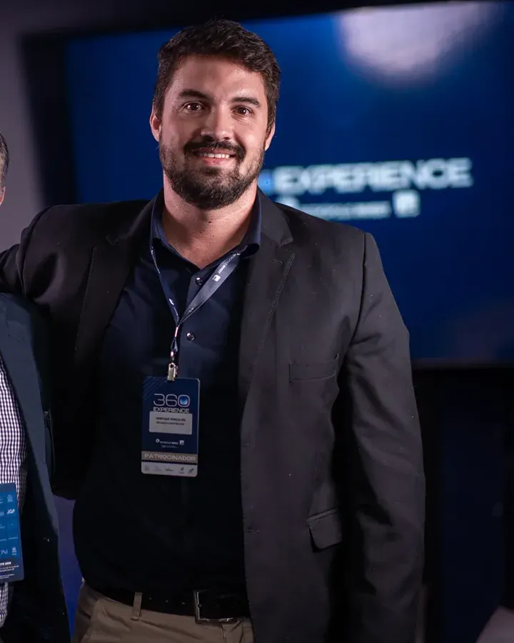 Participante com crachá do evento diante do painel do 360 Experience