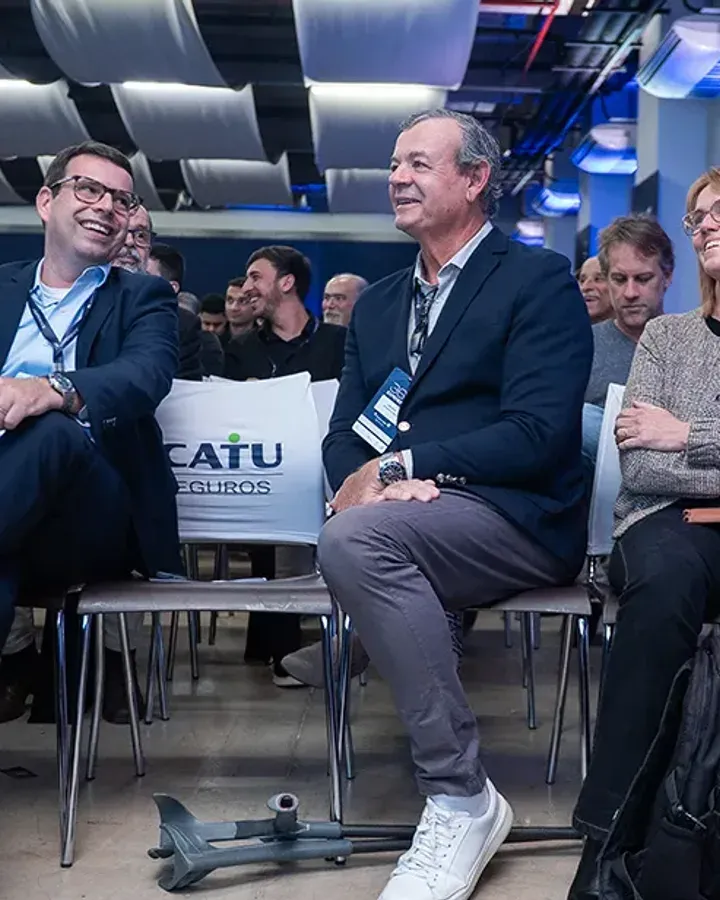 Participantes sentados na plateia, sorrindo durante a 1ª edição